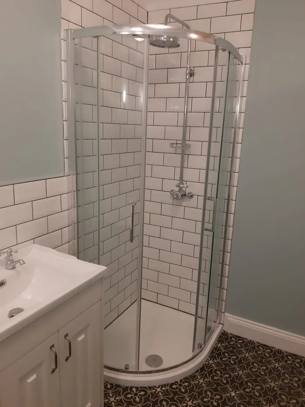 a bathroom with a walk in shower next to a sink
