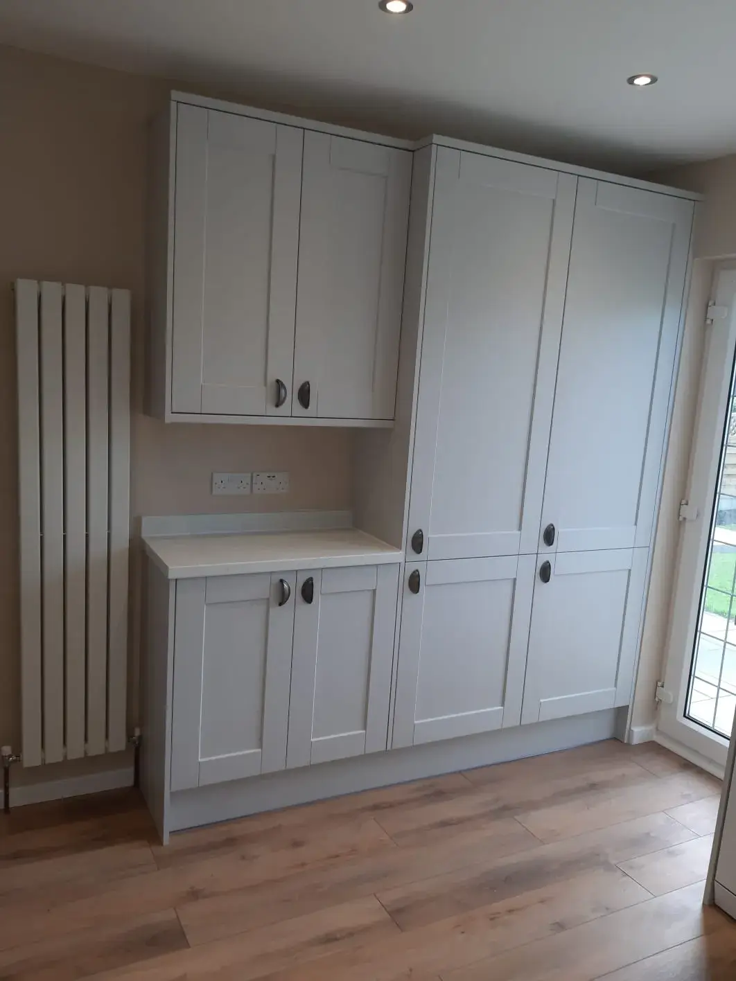 a kitchen with white cabinets and wood floors