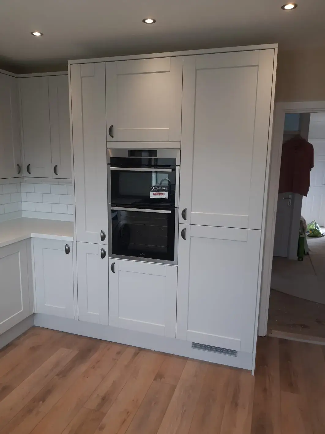 A kitchen with white cabinets and a black oven.