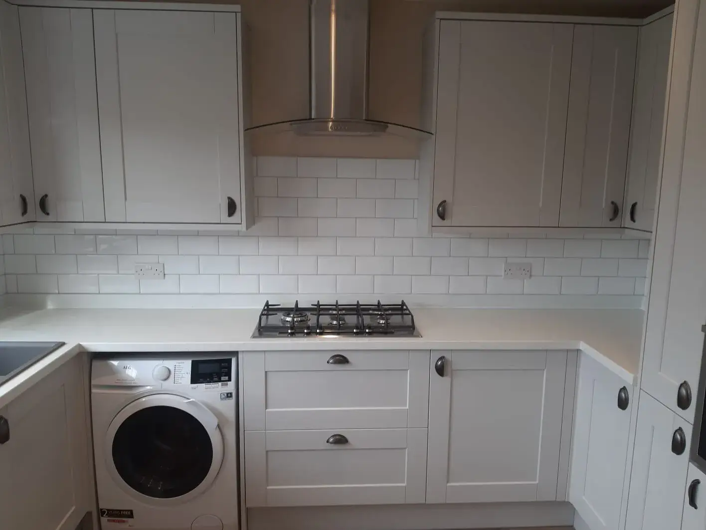 a white kitchen with a washer and dryer