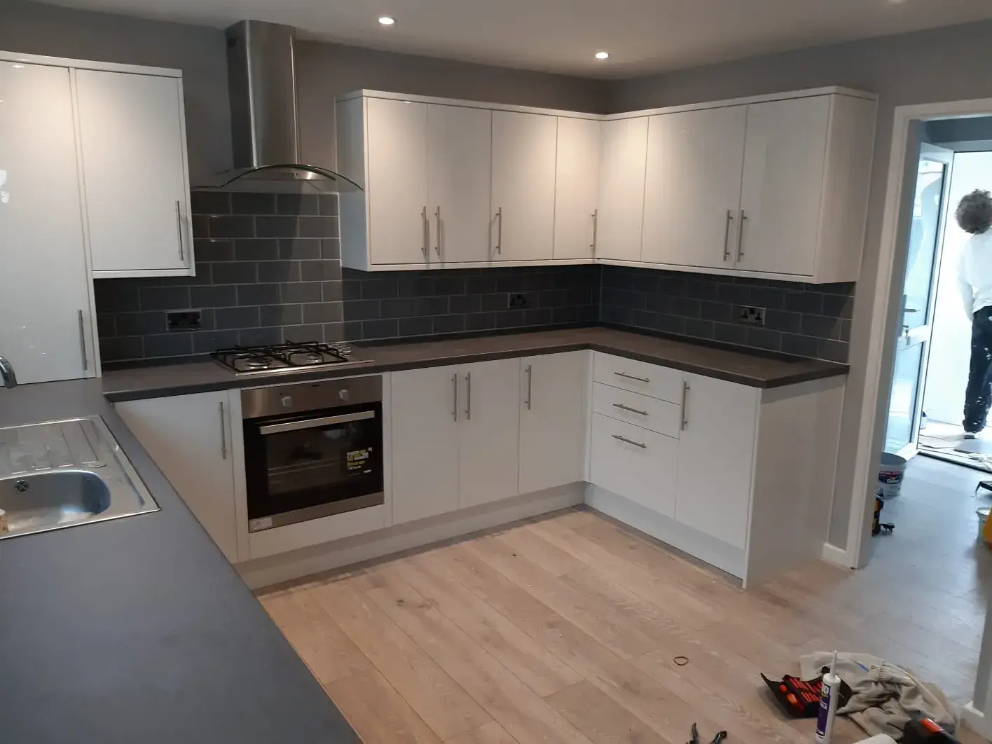 a kitchen with a stove top oven and white cabinets