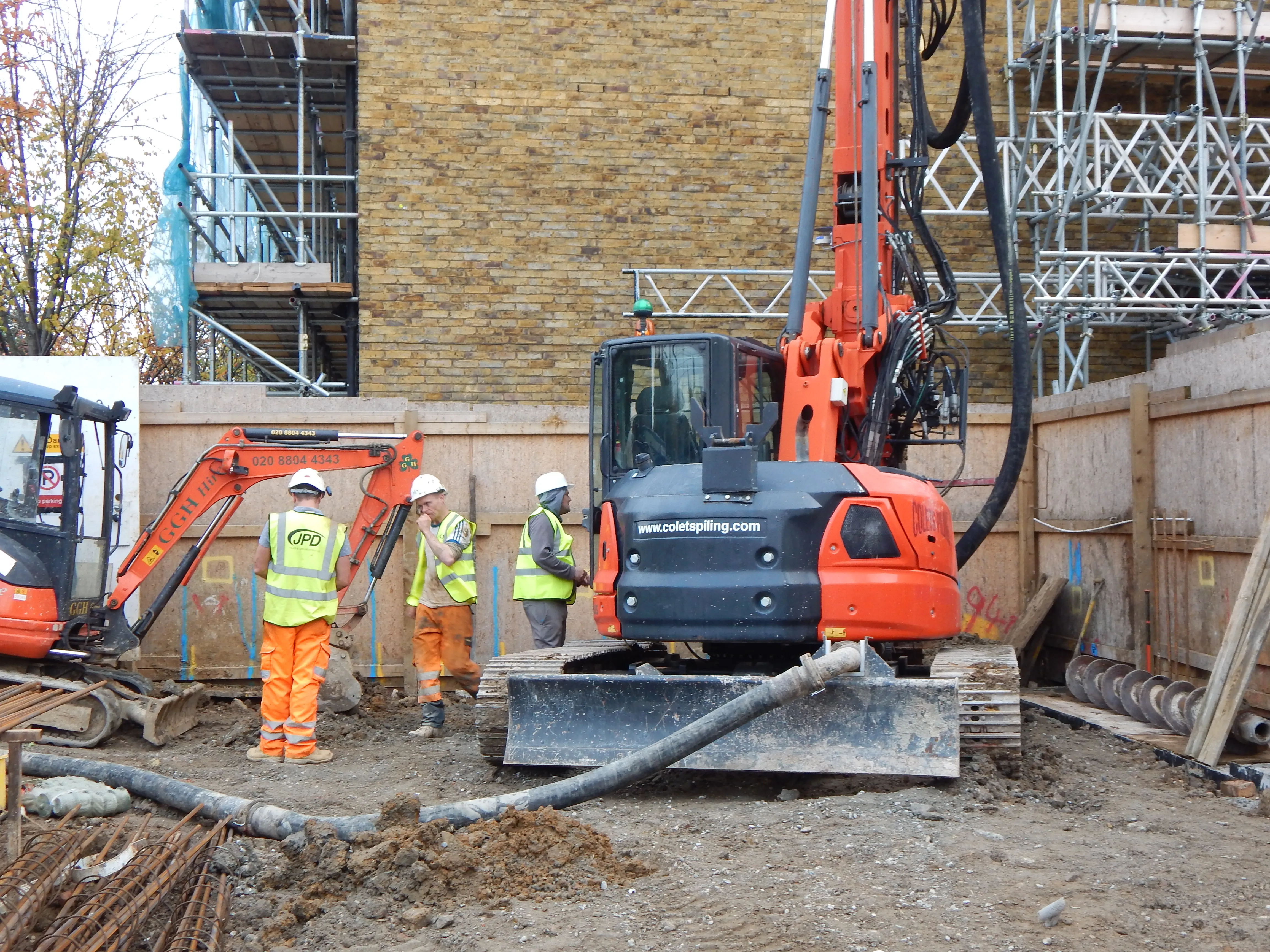 A couple of men standing in front of a construction site.