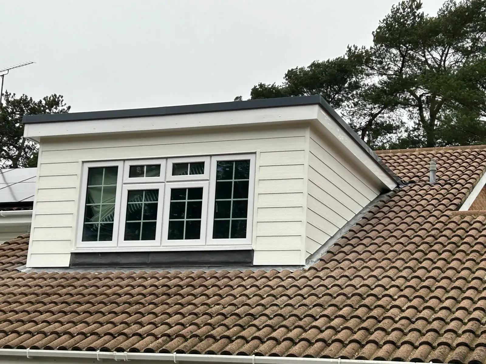 a close up of a roof with a window and a roof fan