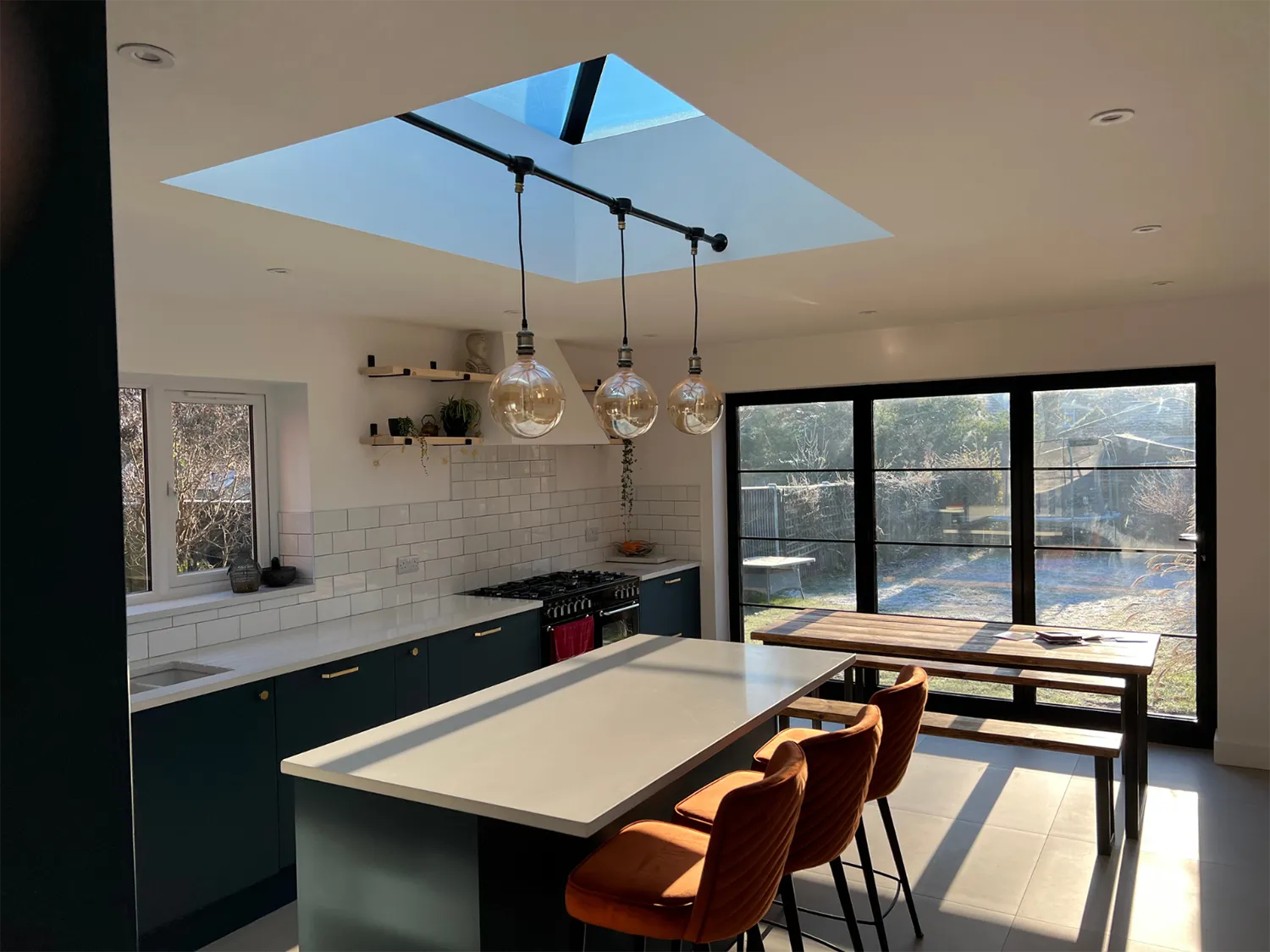 a kitchen with a table, chairs, and a skylight