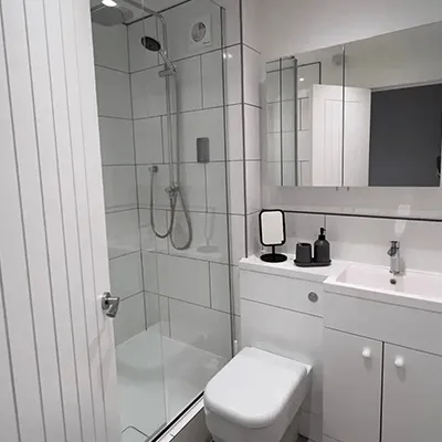 A bathroom with a toilet, sink, and shower.